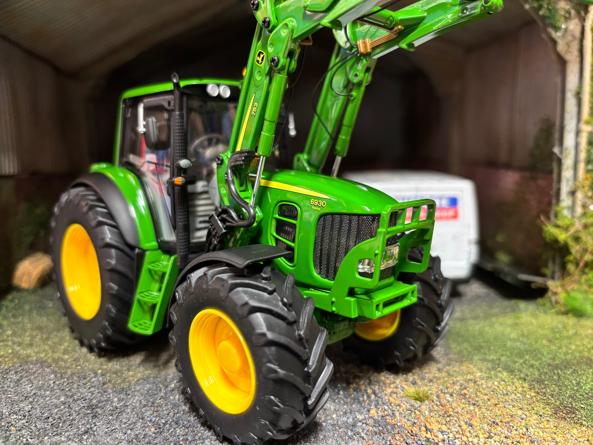 Wiking John Deere 6930 premium tractor with 753 loader, 1:32 scale, green with yellow wheels and loader raised.