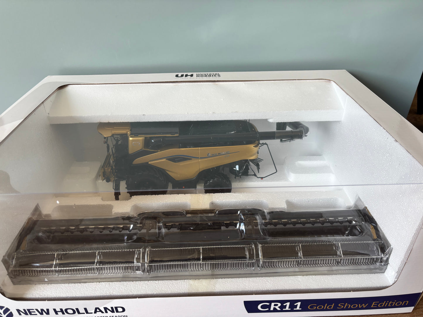 1:32 scale New Holland CR11 Gold Show Edition combine harvester by Universal Hobbies UH6829 in display packaging.